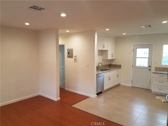 a kitchen with a refrigerator and white cabinets