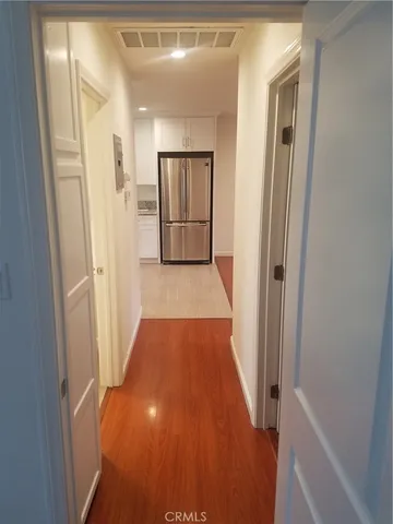 a view of a hallway with wooden floor and staircase