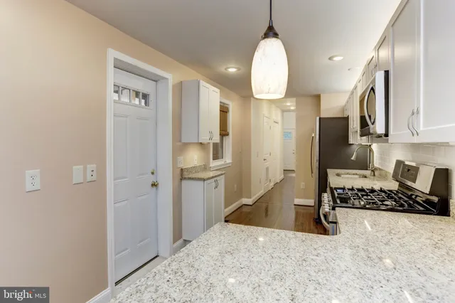 a kitchen with stainless steel appliances granite countertop a refrigerator a sink and a stove