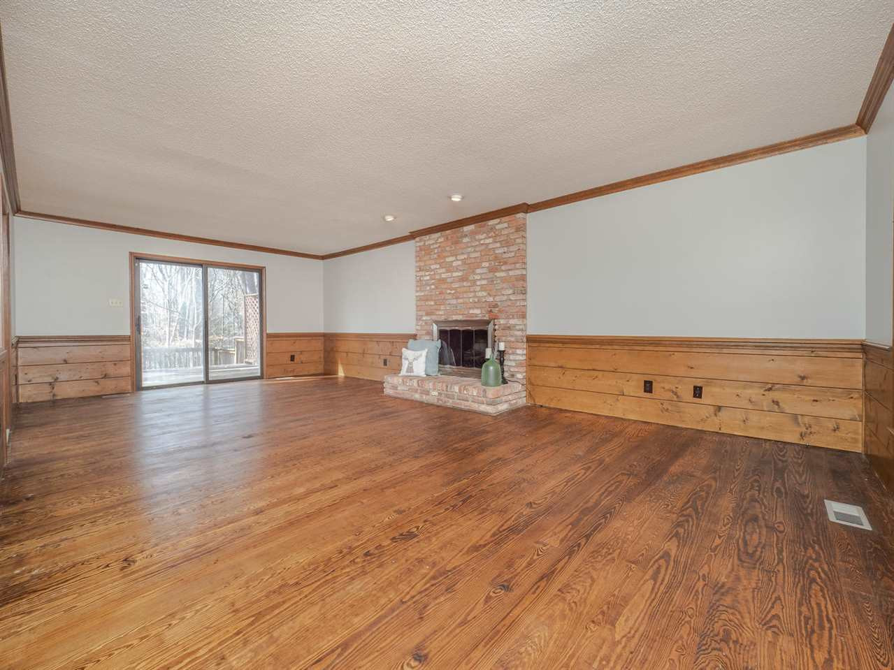 8317 Druids Lane Raleigh, NC 27613 - Photo 6 of 24 Family room runs the length of the house, with gorgeous heart pine floors, a masonry fireplace, tons of moldings and sliding door access to the backyard. Family Room