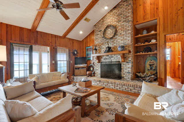30234 River Road Orange Beach, AL 36561 - Photo 3 of 23 Great room has knotty cypress paneling throughout, wood flooring, wood burning fireplace and opens to the sun room.