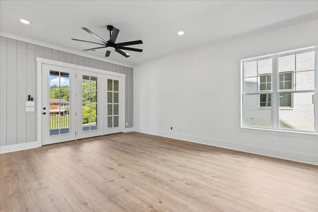 a view of empty room with wooden floor and fan