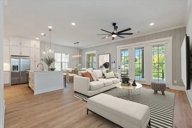 a living room with furniture and a large window with kitchen view