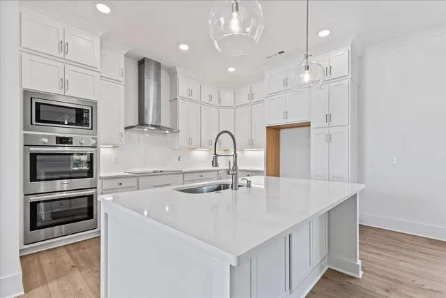 a kitchen with kitchen island stainless steel appliances a sink and a refrigerator