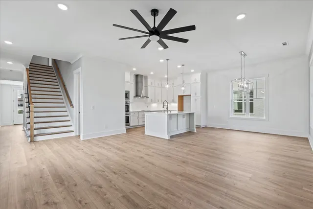 a view of a kitchen with a sink and dishwasher a refrigerator with wooden floor