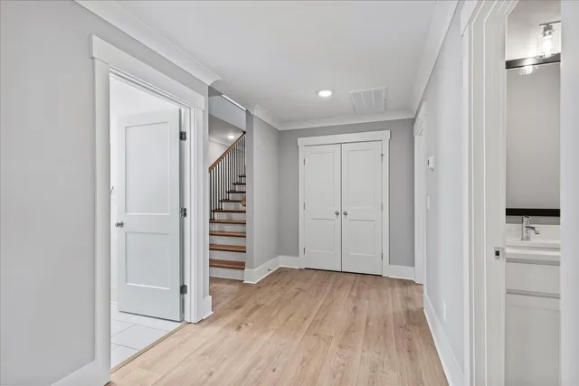 a view of a hallway with wooden floor and staircase