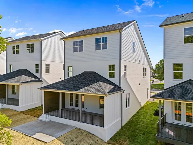 a view of a white house next to a yard
