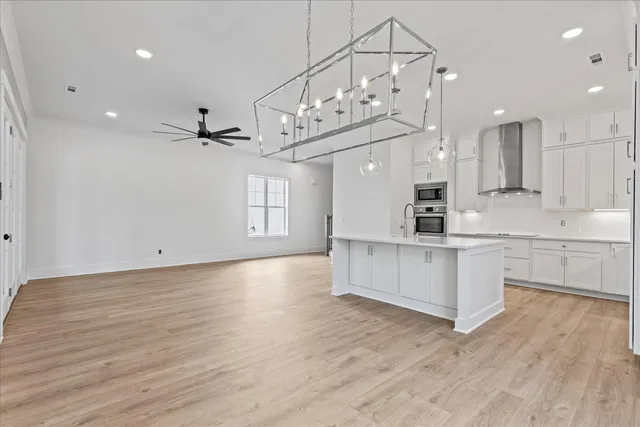 a large white kitchen with lots of counter space wooden floor and appliances