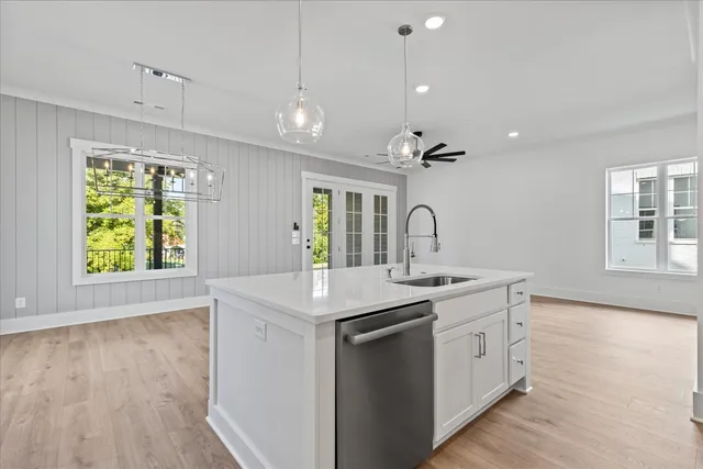 a kitchen with a sink a window and wooden floor