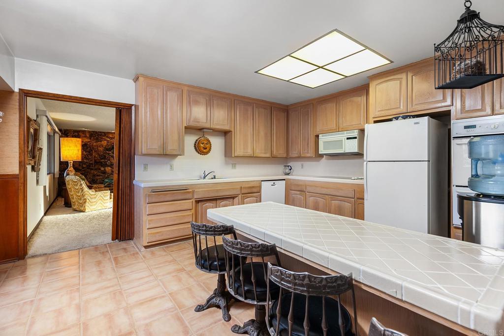 2686 Via Viejas Alpine, CA 91901 - Photo 12 of 64 a kitchen with a table chairs refrigerator and cabinets