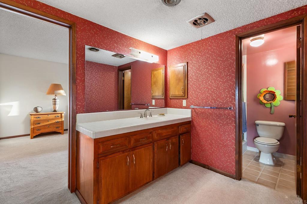 2686 Via Viejas Alpine, CA 91901 - Photo 22 of 64 a bathroom with a granite countertop sink a toilet and a mirror