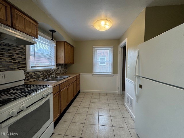 520 8th Street Struthers, OH 44471 - Photo 16 of 22 Kitchen featuring light tile patterned flooring, backsplash, white appliances, decorative light fixtures, and sink