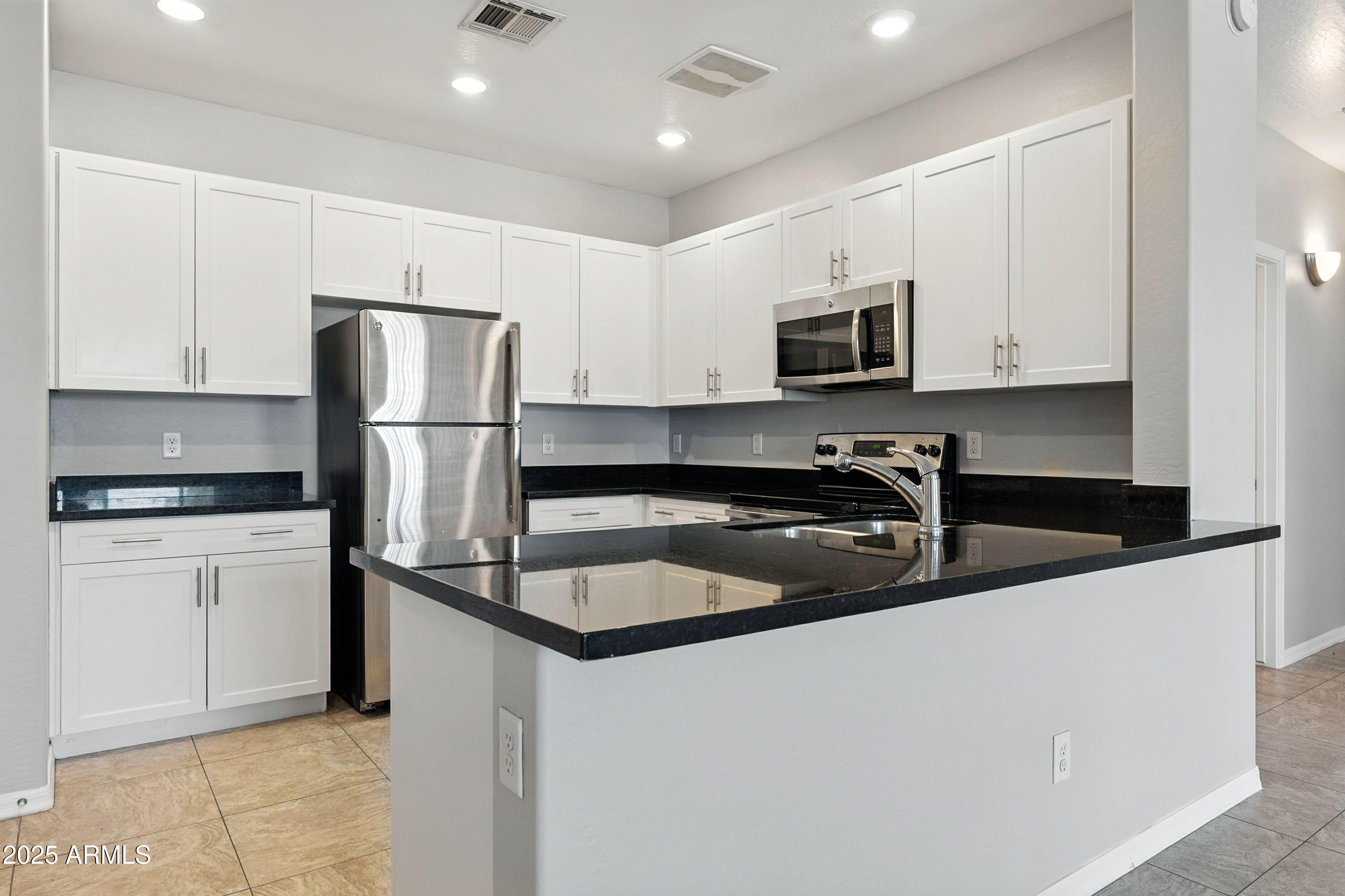 3330 South Gilbert Road, Unit 2062 Chandler, AZ 85286 - Photo 10 of 61 a kitchen that has a refrigerator a stove and white cabinets