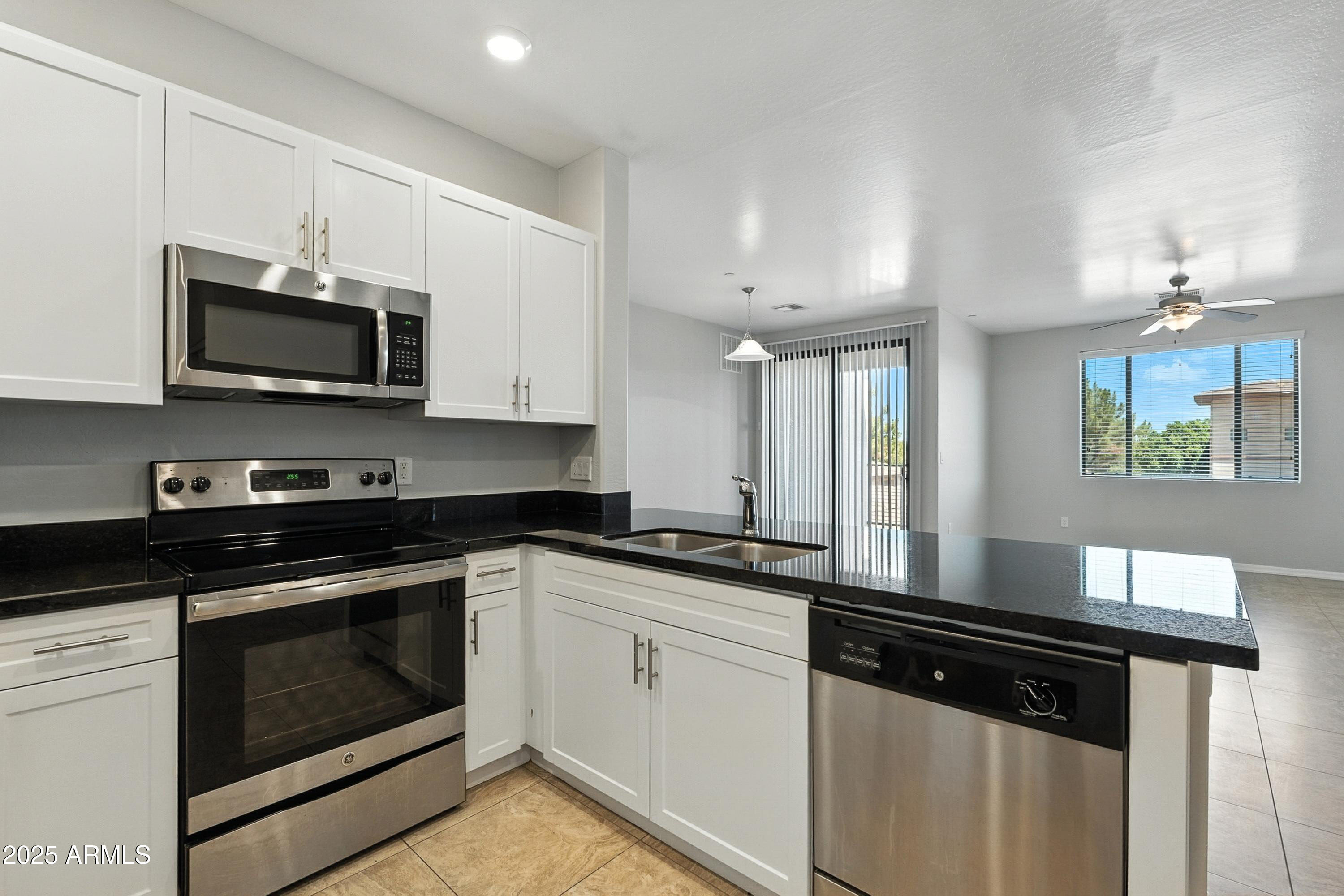 3330 South Gilbert Road, Unit 2062 Chandler, AZ 85286 - Photo 12 of 61 a kitchen with stainless steel appliances granite countertop a stove microwave and sink