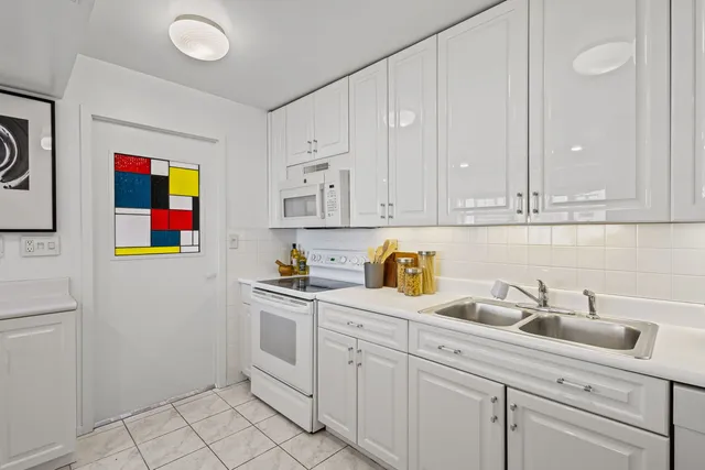 a kitchen with stainless steel appliances white cabinets and a sink
