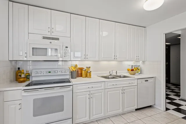 a kitchen with white cabinets and white appliances