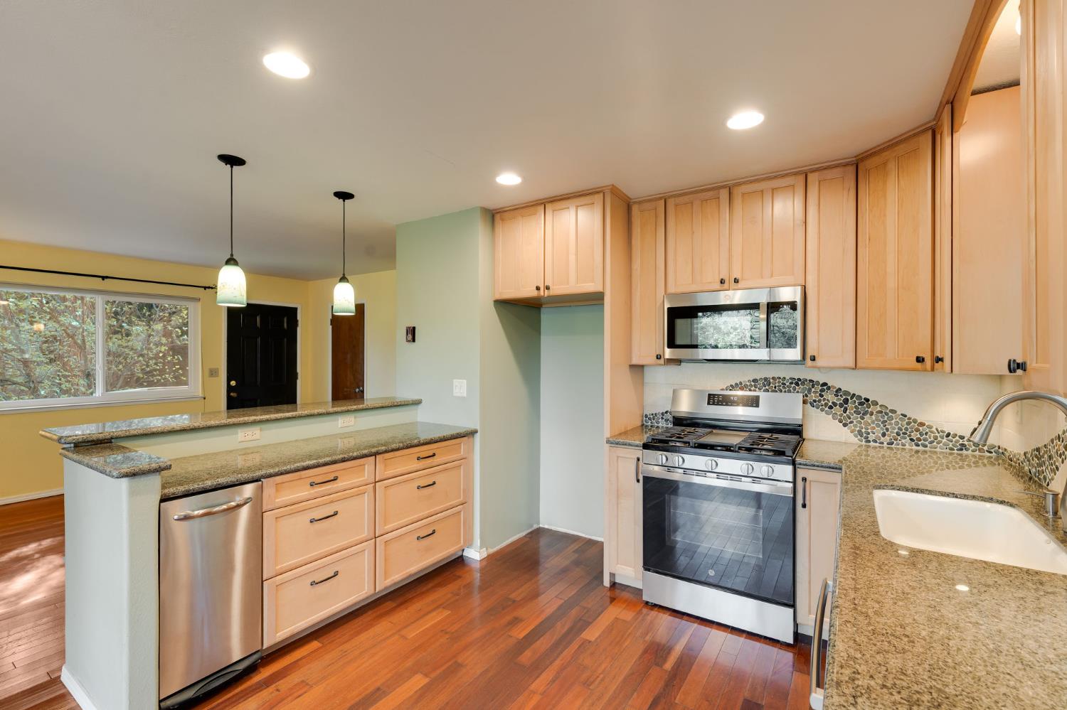 6139 Shad Way Pollock Pines, CA 95726 - Photo 11 of 49 a kitchen with kitchen island granite countertop a sink cabinets and stainless steel appliances