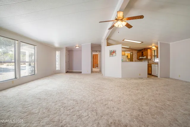 a view of a livingroom with a ceiling fan and window