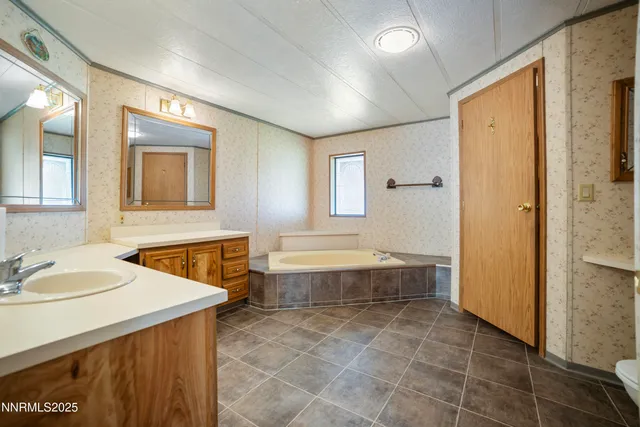 a bathroom with a tub sink and mirror
