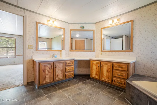 a spacious bathroom with a double vanity sink a mirror and a bathtub