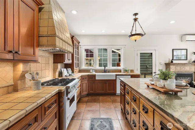 a kitchen with stainless steel appliances granite countertop a sink a stove and a wooden cabinets