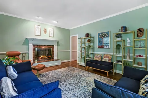 a living room with furniture a fireplace and a large window