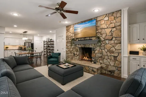 a kitchen with stainless steel appliances granite countertop a stove a sink a dining table and chairs with wooden floor