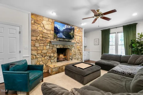 a kitchen with stainless steel appliances a stove a sink dishwasher a refrigerator cabinets and a dining table with wooden floor