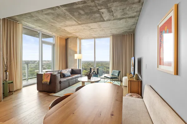 a living room with furniture and floor to ceiling windows