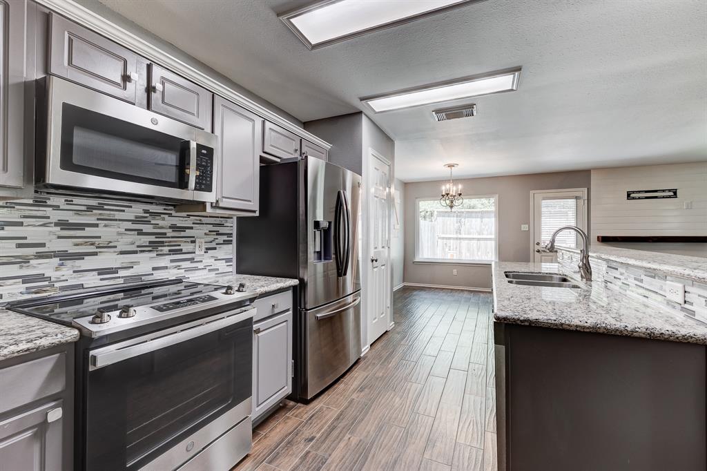 a kitchen with stainless steel appliances a stove microwave and refrigerator