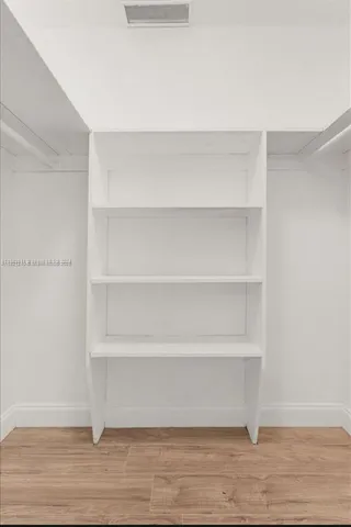 a view of a room with shelf and wooden floor