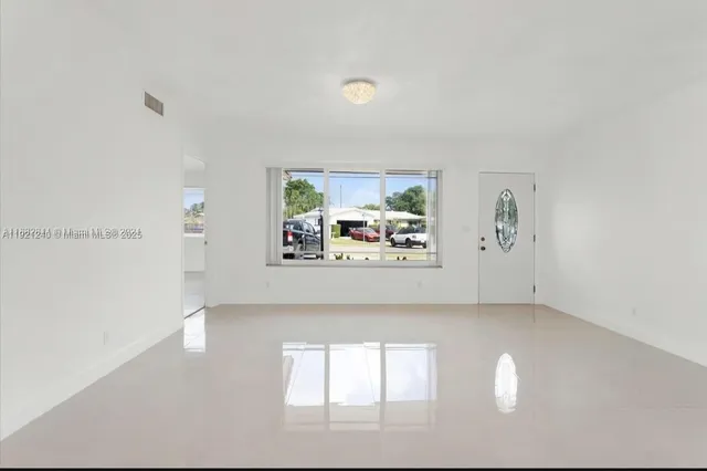 an empty room with windows and cabinet