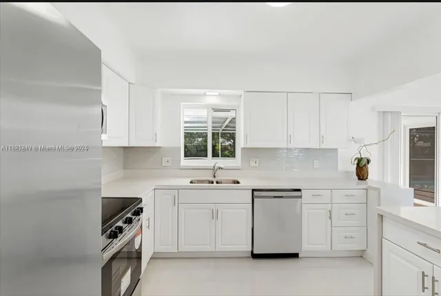 a kitchen with a sink a stove and cabinets