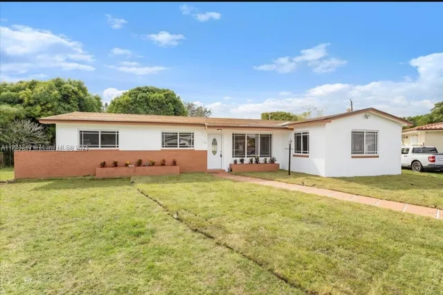 a backyard of a house with table and chairs