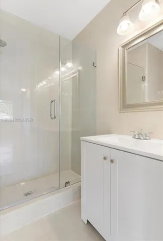 a bathroom with a shower sink and mirror