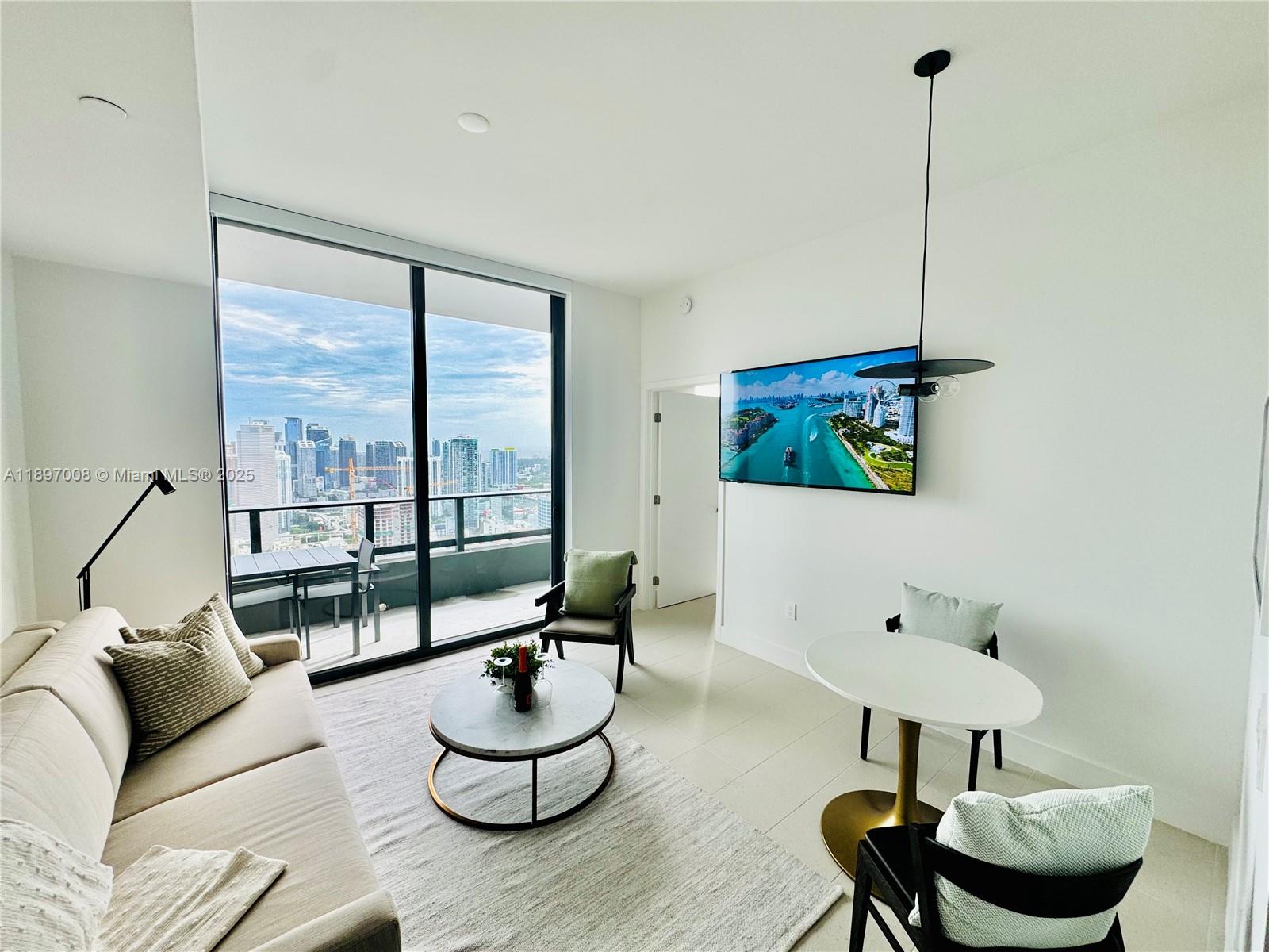 159 Northeast 6th Street, Unit 4807 Miami, FL 33132 - Photo 12 of 63 a living room with furniture and a floor to ceiling window