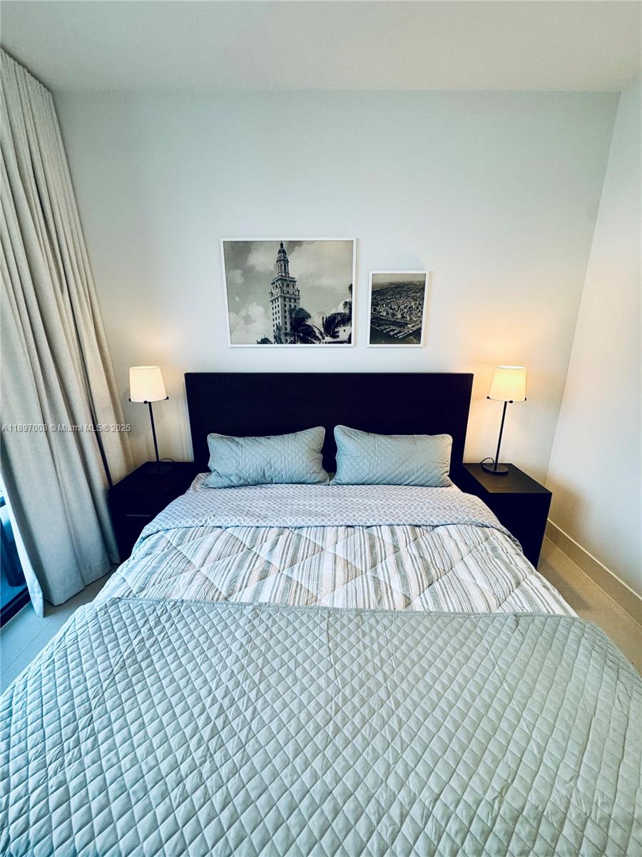 159 Northeast 6th Street, Unit 4807 Miami, FL 33132 - Photo 21 of 63 a bedroom with a bed and wooden floor