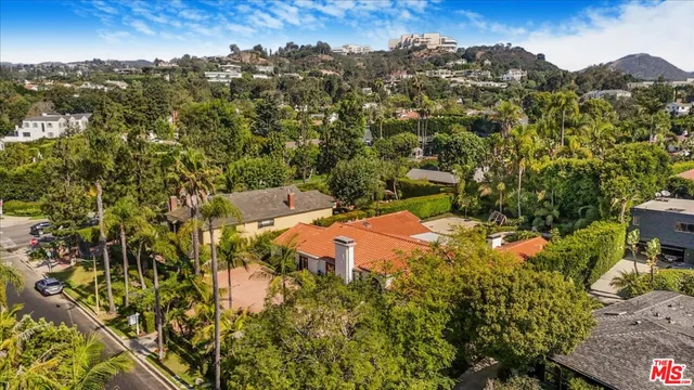 a front view of a house with a yard and potted plants
