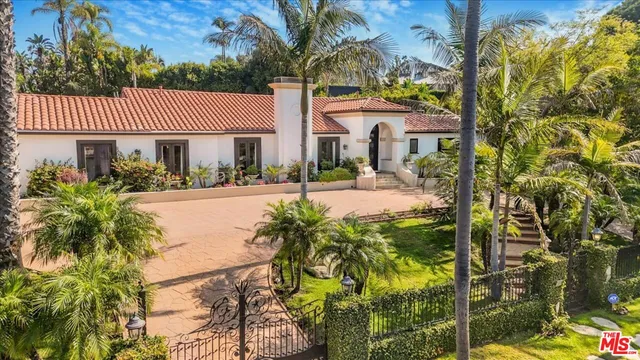a view of a house with a yard and potted plants