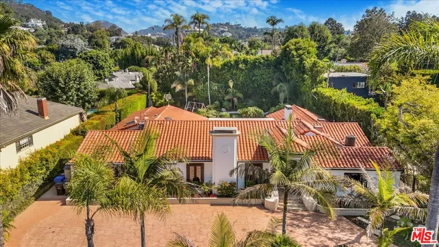 a view of a house with a yard and potted plants