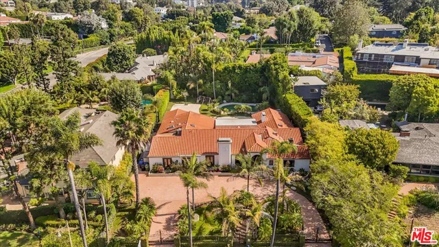 an aerial view of residential houses with outdoor space and trees