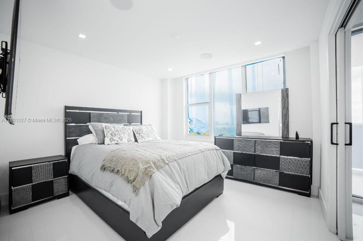 5600 Collins Avenue, Unit 14K Miami Beach, FL 33140 - Photo 16 of 27 a bedroom with a bed and a couch