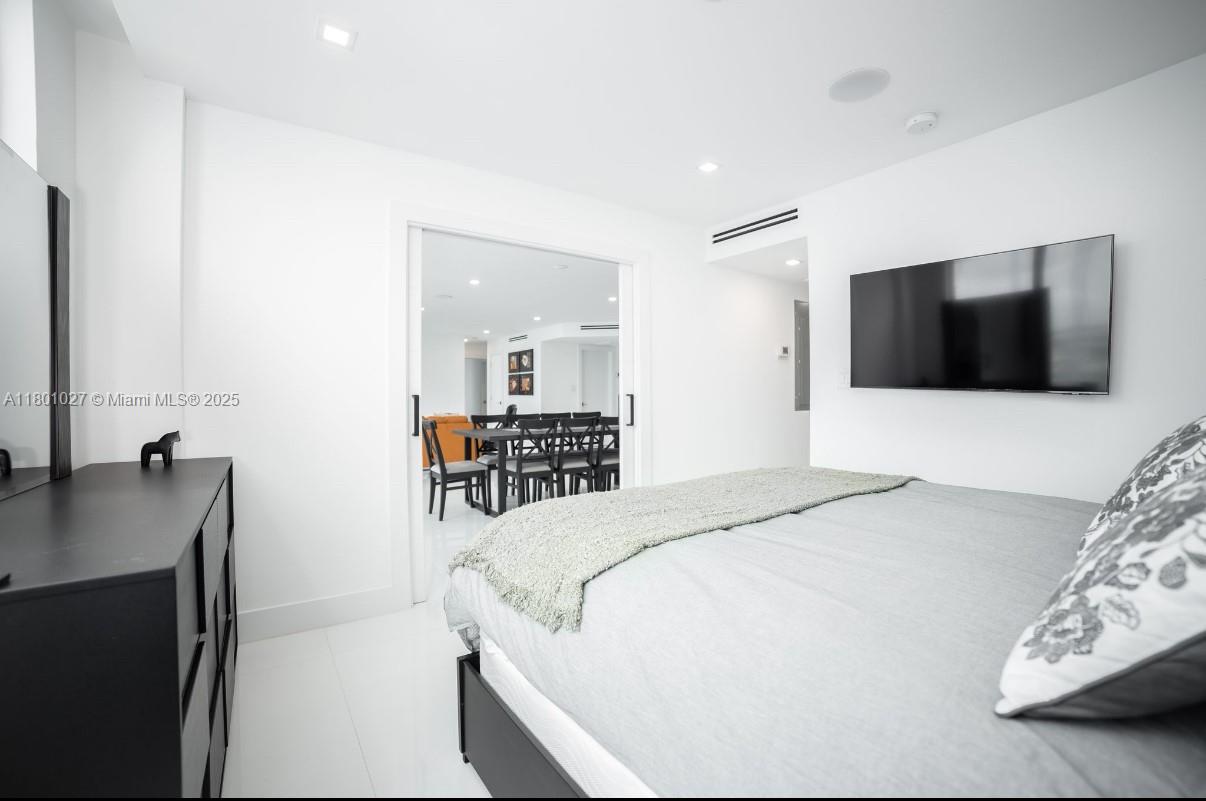 5600 Collins Avenue, Unit 14K Miami Beach, FL 33140 - Photo 17 of 27 a bedroom with a bed and a flat screen tv