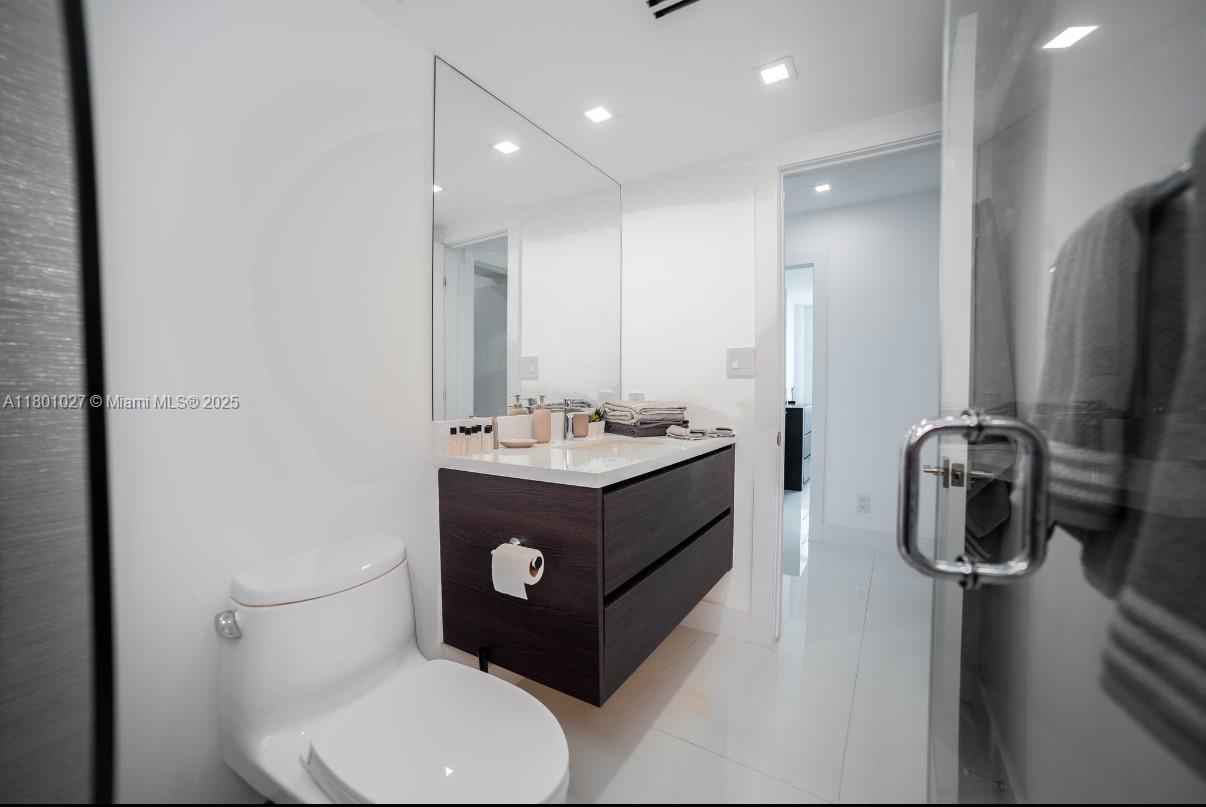 5600 Collins Avenue, Unit 14K Miami Beach, FL 33140 - Photo 18 of 27 a bathroom with a toilet sink and mirror