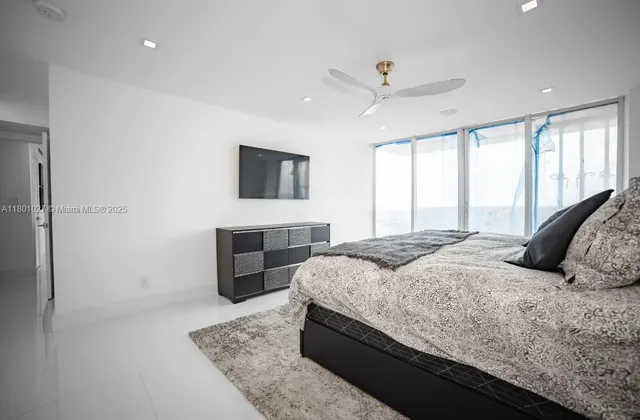 a bedroom with a large bed and a flat screen tv