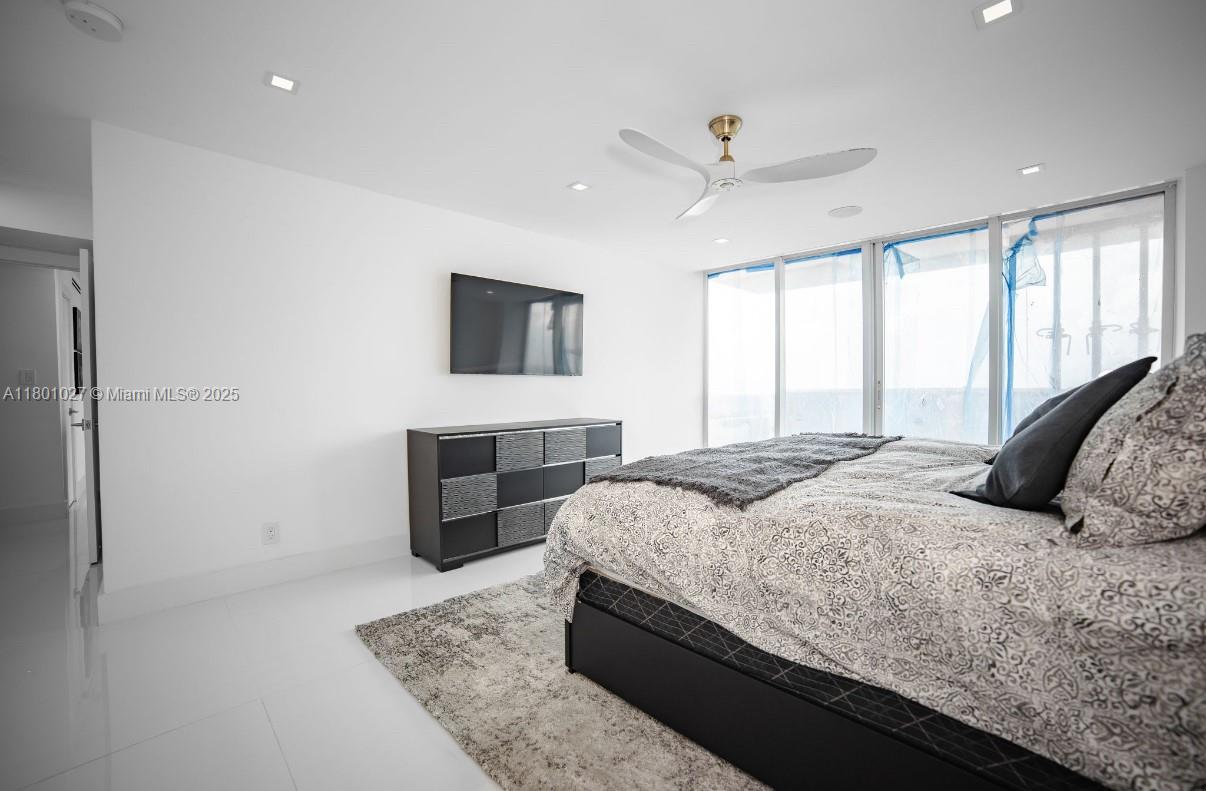 5600 Collins Avenue, Unit 14K Miami Beach, FL 33140 - Photo 21 of 27 a bedroom with a large bed and a flat screen tv