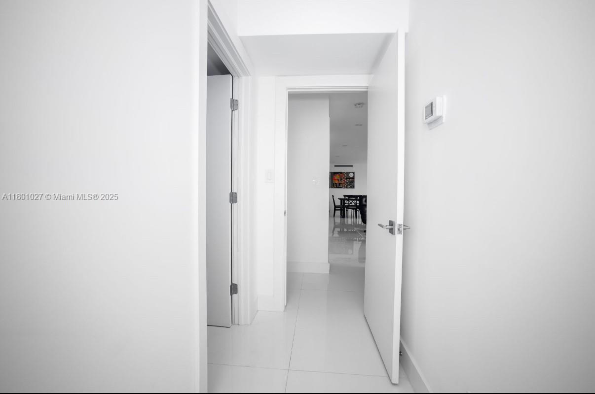 5600 Collins Avenue, Unit 14K Miami Beach, FL 33140 - Photo 24 of 27 a view of a hallway with wooden floor and a bathroom