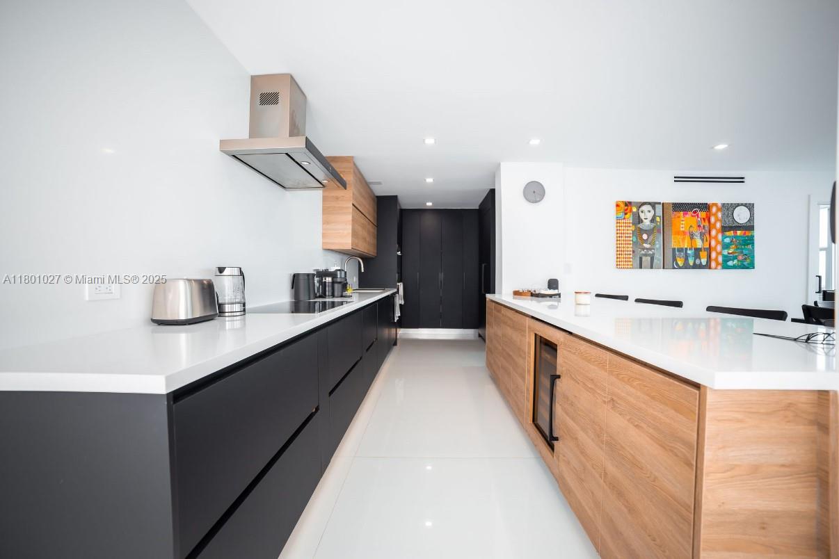 5600 Collins Avenue, Unit 14K Miami Beach, FL 33140 - Photo 4 of 27 a large white kitchen with a large counter top and stainless steel appliances