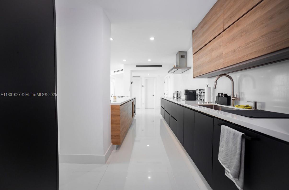5600 Collins Avenue, Unit 14K Miami Beach, FL 33140 - Photo 5 of 27 a kitchen with stainless steel appliances granite countertop a sink a stove and a refrigerator