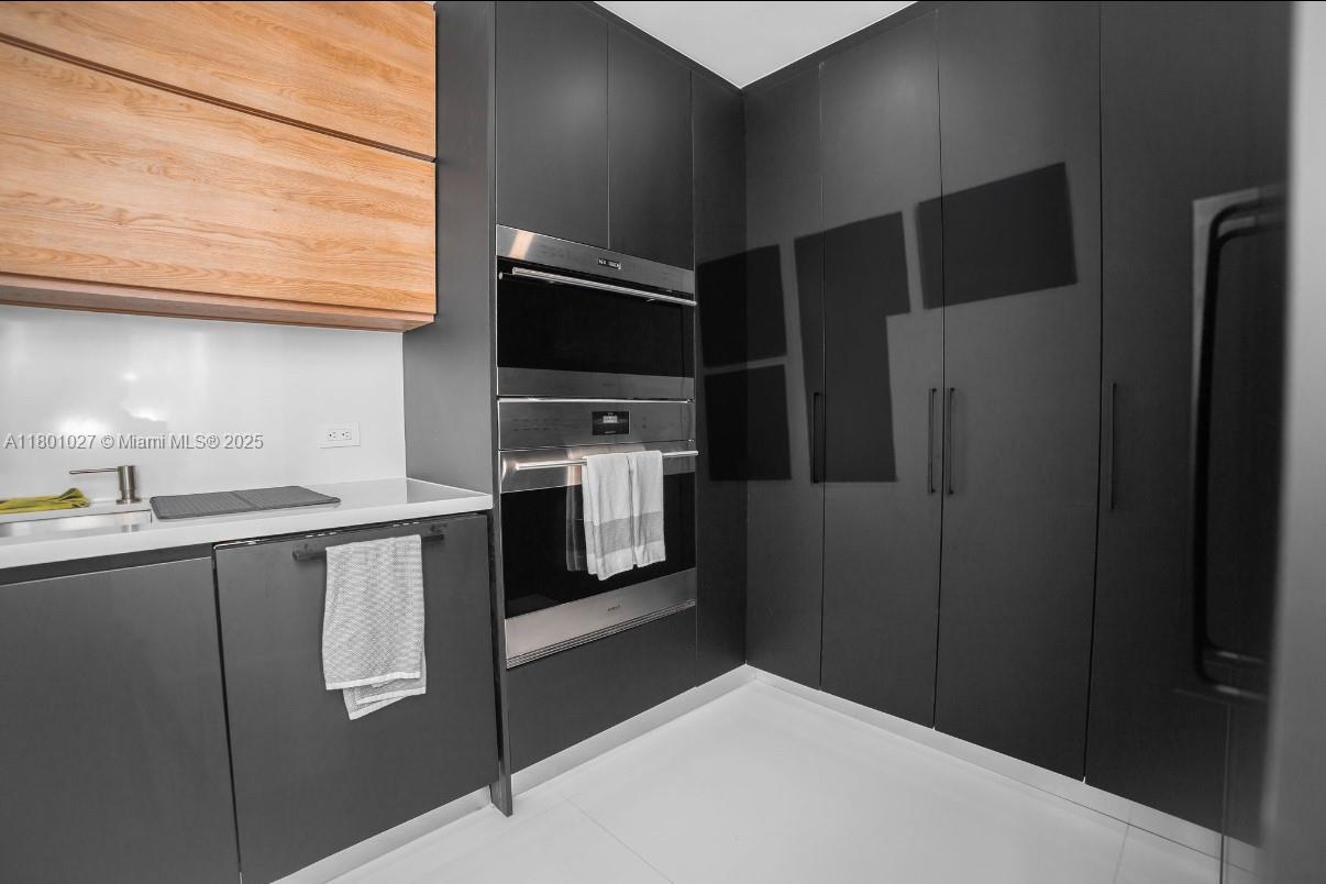 5600 Collins Avenue, Unit 14K Miami Beach, FL 33140 - Photo 6 of 27 a kitchen with stainless steel appliances a refrigerator and a stove top oven